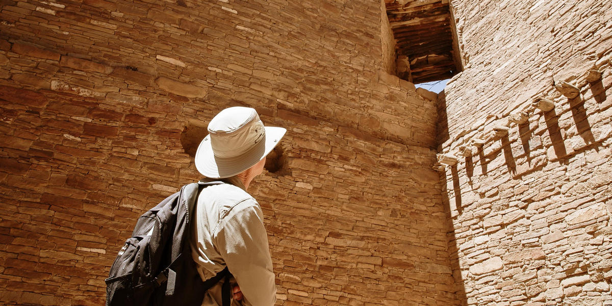 Person looking up at wall in Chaco Canyon